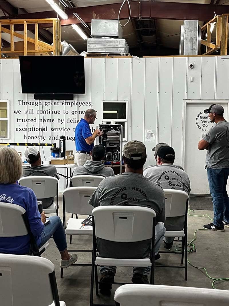 Instructor teaching plumbing training class at Quality Service Company with students learning hands-on skills in a workshop environment Plumbing training class  Hands-on plumbing education  Plumbing certification course  Learn plumbing skills  Quality Service Company plumbing school  Trade training in plumbing  Plumbing career training