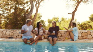 People sitting by a pool, talking.