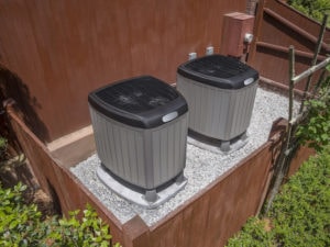 Residential heating and air conditioner compressor units near residential house