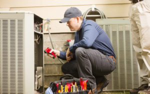 An HVAC technician in Florence, SC, performing a maintenance inspection on a homeowner's A/C unit.