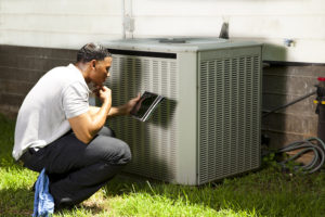 Service technician inspecting air conditioning unit to prepare the system for a hurricane