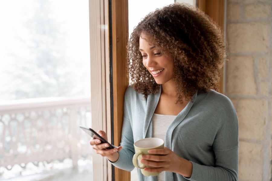 Woman researching how to make her furnace last longer on her phone.