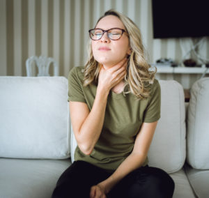 Woman with sore throat trying to determine what accessories can help improve her home's indoor air quality.