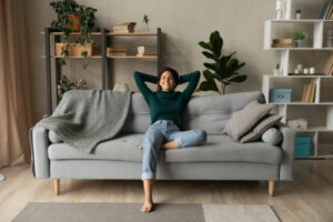 Blog Title: How a Whole-House Humidifier Keeps You Healthy Photo: Woman relaxing on a coach in her living room