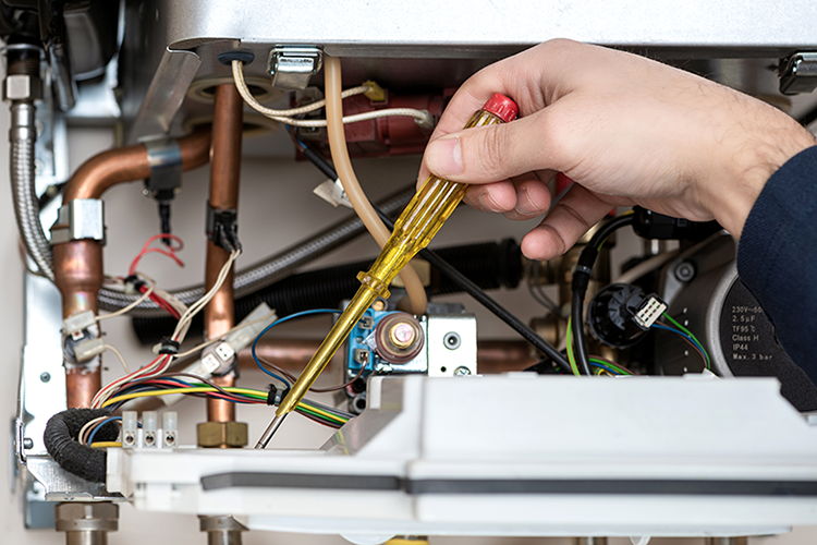 Image of someone working on a furnace. How Does My Gas Furnace Work.