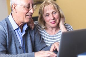 How to Determine Heat Pump Efficiency. Image shows couple sitting together and looking at an open laptop.