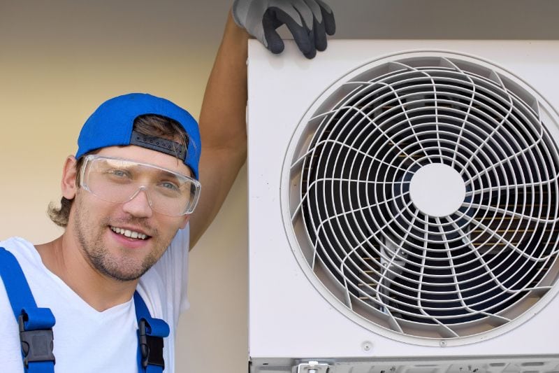 Fall HVAC Maintenance - Maintenance Man Repairing an HVAC System Outdoors.